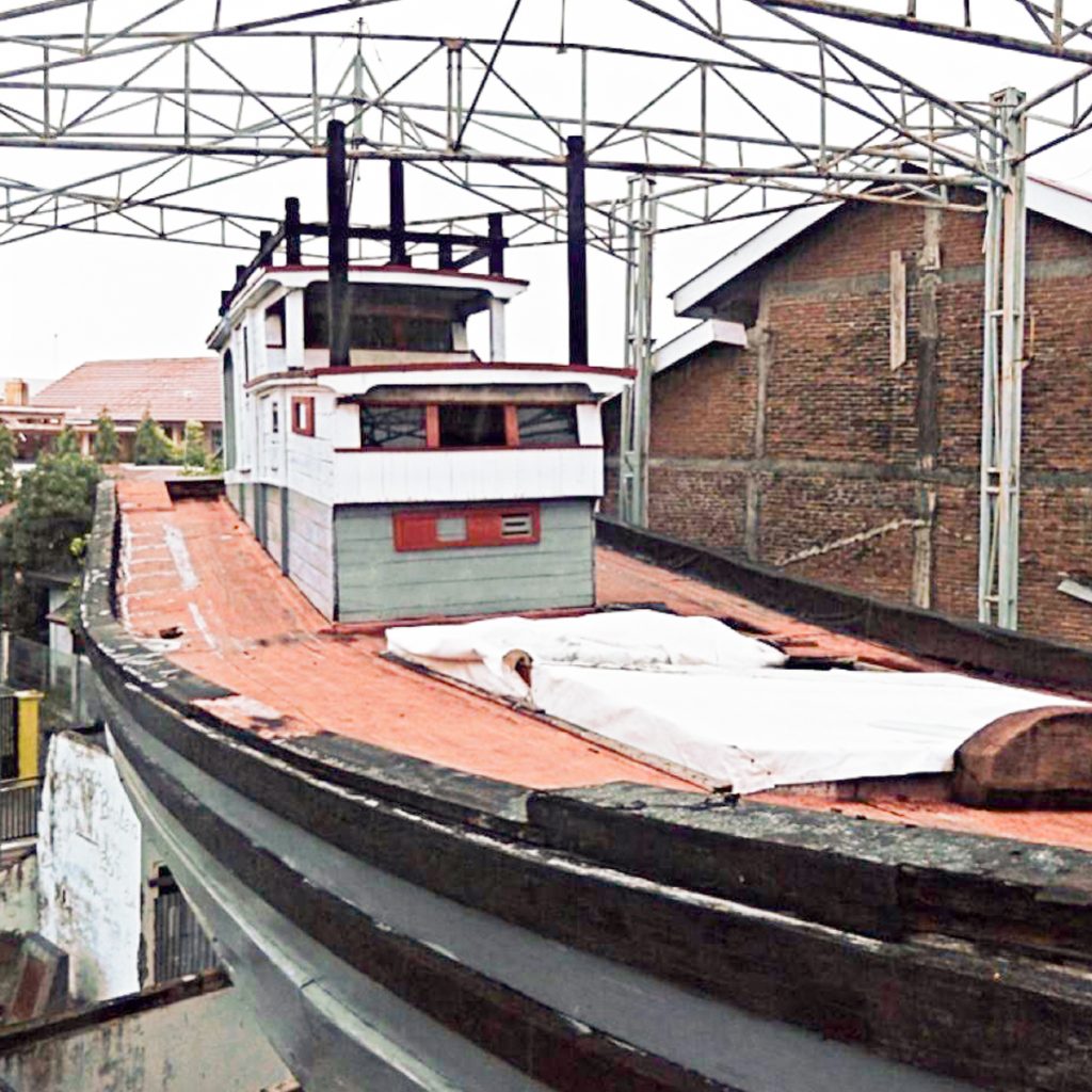 Image of a large boat sitting on top of a damaged house