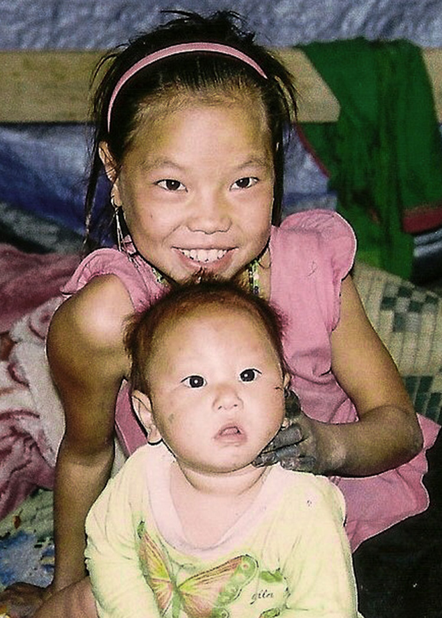 Image of two children looking away from camera and smiling