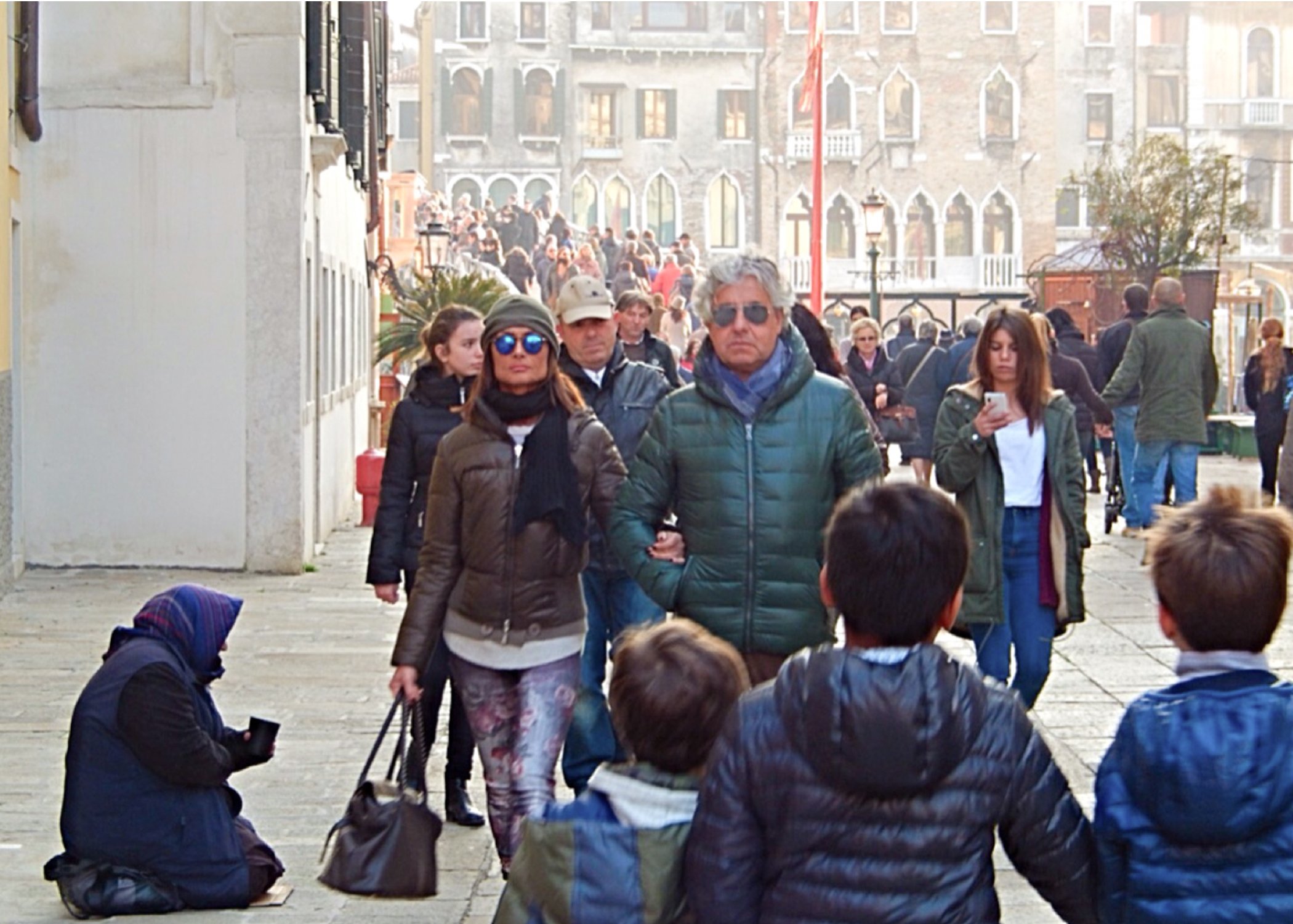 Image of people walking past a woman beggar